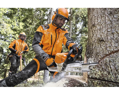 Forstarbeiter in Stihl Schutzkleidung sägen Baumstamm mit Stihl Motorsäge im Wald.