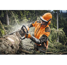 Forstarbeiter bei der Arbeit mit einer Stihl Motorsäge in einem Wald, trägt Schutzkleidung inklusive Helm mit Visier und Gehörschutz.