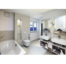 Modernes Badezimmer mit Doppelwaschtisch, wandhängender Toilette und Badewanne in heller Ausstattung mit indirekter Beleuchtung.