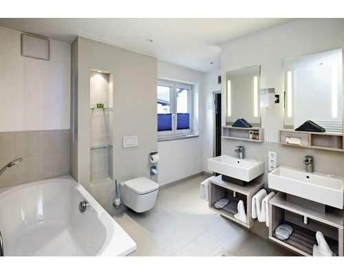Modernes Badezimmer mit Doppelwaschtisch, wandhängender Toilette und Badewanne in heller Ausstattung mit indirekter Beleuchtung.