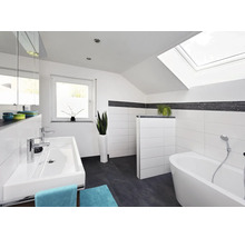 Modernes Badezimmer mit Dachschräge, weiß gefliesten Wänden, dunklen Bodenfliesen, Doppelwaschtisch und freistehender Badewanne unter Dachfenster.