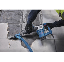 Handwerker entfernt Fliesen mit einem Bosch Professional Abbruchhammer mit angeschlossener Staubabsaugung auf einer Baustelle.