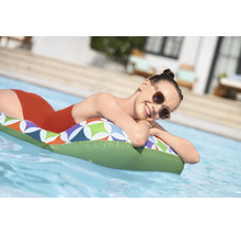 Eine Frau entspannt auf einer gemusterten Luftmatratze im Pool.