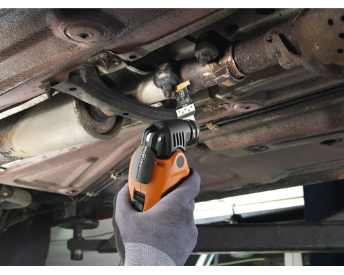 Multifunktionswerkzeug beim Einsatz am Auto unter dem Fahrzeugboden zum Schneiden von Metallteilen.