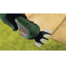 Eine handgehaltene Bosch Akku Grasschere mit Ladestatusanzeige in einer mit Arbeitshandschuhen bekleideten Hand.