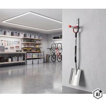 Spaten an einem Wandhalter in einer aufgeräumten Garage mit Werkbank und Fahrradaufhängung. (Image AI modified or generated)