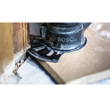 Bosch Multifunktionswerkzeug mit Tauchsägeblatt schneidet einen Holzboden bündig an einer Wand ab.
