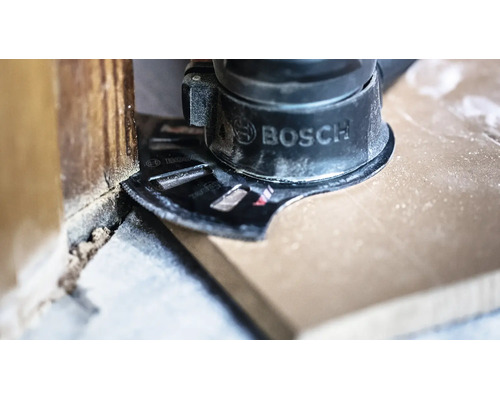 Bosch Multifunktionswerkzeug mit Tauchsägeblatt schneidet einen Holzboden bündig an einer Wand ab.