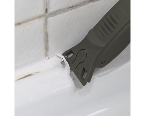 Fugenkratzer beim Entfernen von alten Silikonfugen zwischen Fliesen und Badewanne