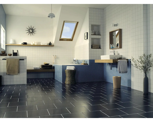 Modernes Badezimmer mit blauen Mosaikfliesen an der Badewanne und quadratischen Wandfliesen, dazu dunkle Bodenfliesen in einem geräumigen Raum.