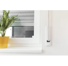Ein Gurtwickler für Rollläden ist flach auf einer Wand neben einem Fenster mit Fensterbank und einer Zimmerpflanze montiert.