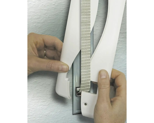 Hände beim Anbringen der Abdeckung eines Rollladengurts an der Wand.