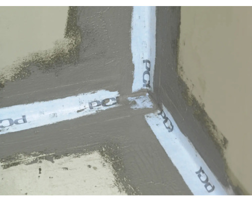 Verbundabdichtung mit PCI Dichtband in einer Innenecke auf Boden und Wand zur Abdichtung im Bad.