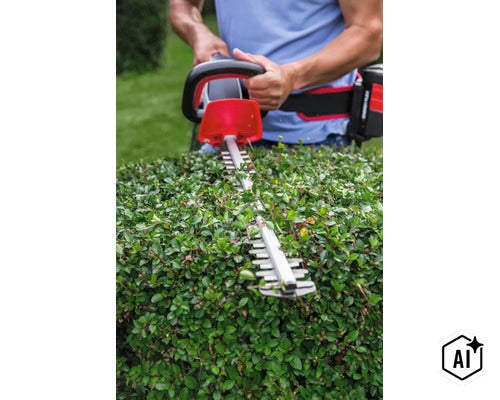 Person verwendet eine Akku Heckenschere zum Schneiden einer Hecke im Garten. (Image AI modified or generated)