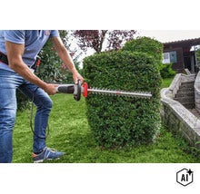 Person schneidet eine Gartenhecke mit einer Akku Heckenschere von AL-KO im Garten. (Image AI modified or generated)