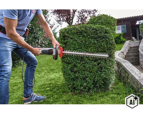 Person schneidet eine Gartenhecke mit einer Akku Heckenschere von AL-KO im Garten. (Image AI modified or generated)
