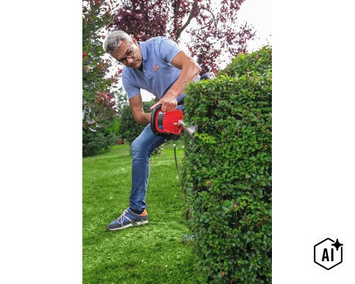 Mann schneidet mit einer elektrischen Heckenschere eine Gartenhecke in einem privaten Garten (Image AI modified or generated)