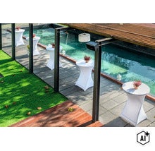 Stehtische mit weißen Hussen entlang eines Pools auf einer Terrasse mit Kunstrasen und einer Holzüberdachung in einer modernen Gartenanlage. (Image AI modified or generated)