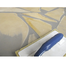 Verfugen von Natursteinplatten im Polygonalverband mit einem Schwammbrett.