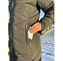 Eine Person trägt eine gesteppte Winterjacke und steckt ein Thermopad Handwärmer Kissen in die Reißverschlusstasche.