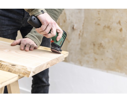 Eine Person schleift Holz mit einem Exzenterschleifer von Bosch