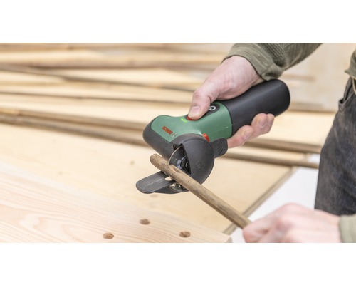 Person schneidet Holzstab mit Akku-Trennschleifer von Bosch