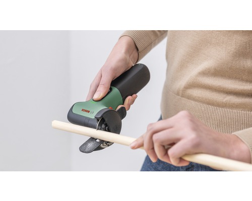 Person schneidet Holzstab mit einem Bosch Multifunktionswerkzeug