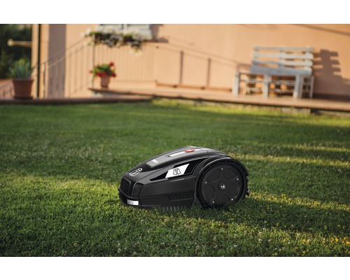 Rasenmähroboter auf einer Rasenfläche vor einem Haus