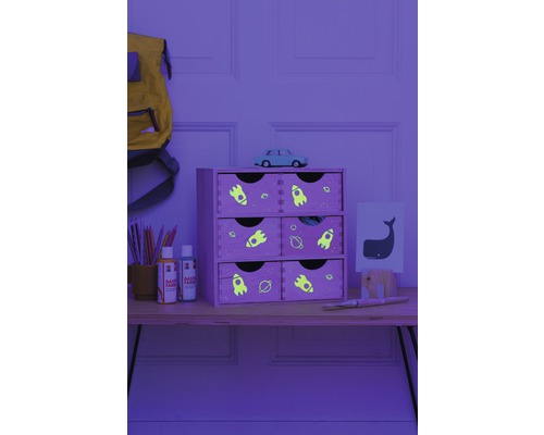 Dekoratives Holzregal mit sechs Schubladen und Weltraummotiven auf einem Tisch mit Malutensilien