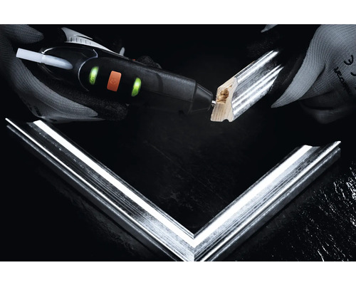 Person leimt Bilderrahmen mit einer Heißklebepistole.