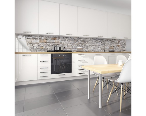 Küchenszene mit Küchenrückwand in Steinoptik, weißen Schränken und Esstisch