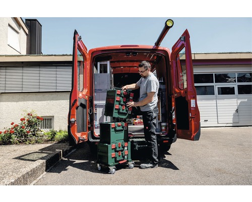 Handwerker mit Werkzeugkoffern vor einem Lieferwagen mit geöffneten Türen