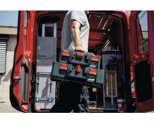 Handwerker trägt zwei Metabo Werkzeugkoffer aus einem Lieferwagen