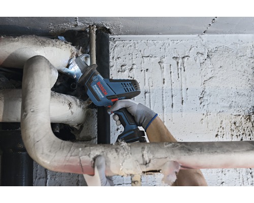 Akkusäge im Einsatz an einem Heizungsrohr, bedient von einer Person mit Handschuhen
