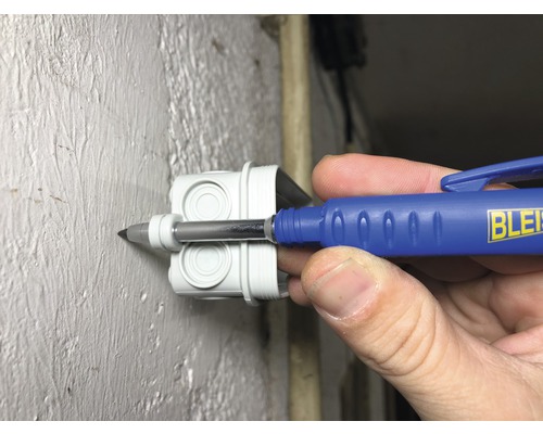 Ein Elektrikerwerkzeug wird in eine weiße Verteilerdose eingeführt.