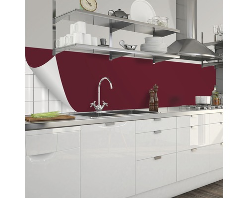 Küchenszene mit roter Küchenrückwand, Spüle und weißen Schränken.