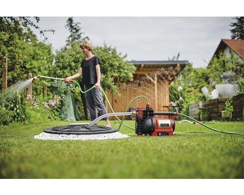 Frau gießt Garten mit Gartenpumpe von Einhell