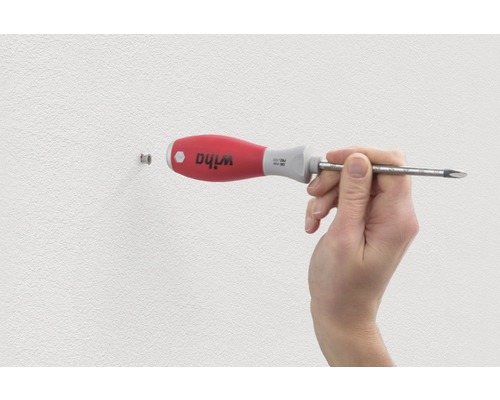 Ein Mann benutzt einen Schlitzschraubendreher der Marke Wiha.