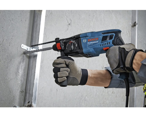 Eine Person bohrt mit einem Bohrhammer von Bosch ein Loch in eine Wand.