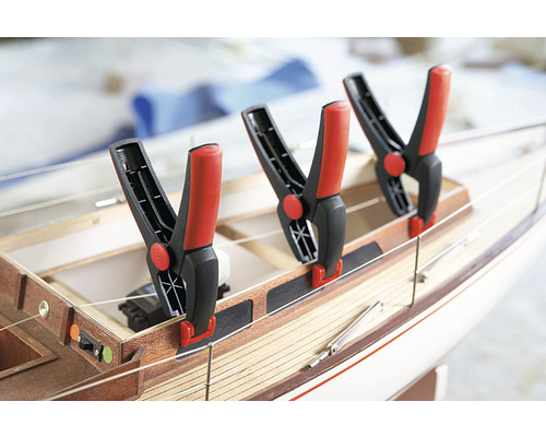 Drei Federzwingen an einem Holzschiffsmodell befestigt