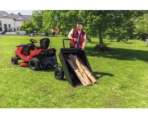Rasentraktor mit Anhänger und Holzstämmen im Garten