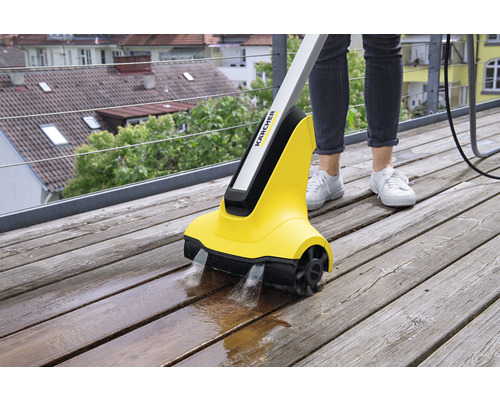 Kärcher Logo. Person reinigt eine Holzterrasse mit einem elektrischen Terrassenreiniger.