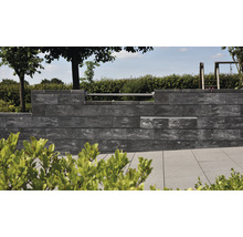 Eine Mauer aus Betonsteinen in einem Garten