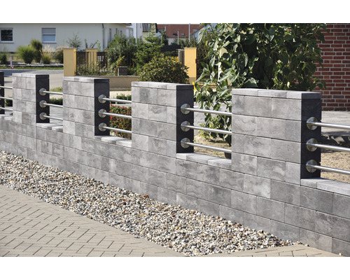 Graue Mauer mit Metallgeländer zur Gartengestaltung
