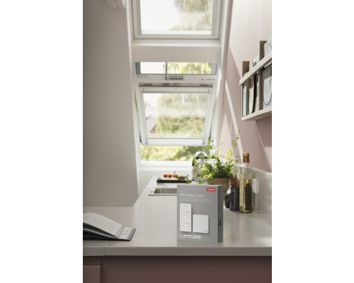 VELUX App Steuerung auf einer Küchentheke mit Dachfenster im Hintergrund