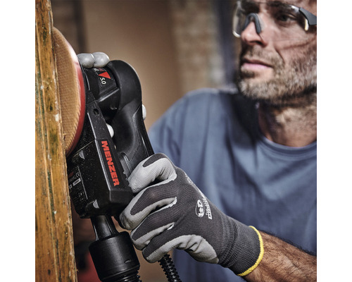 Ein Mann verwendet eine Menzer Wand- und Deckenschleifmaschine zum Schleifen eines Holzes.