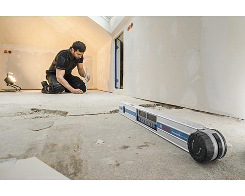 Ein Handwerker arbeitet mit einem digitalen Neigungsmesser von Bosch in einem Raum.
