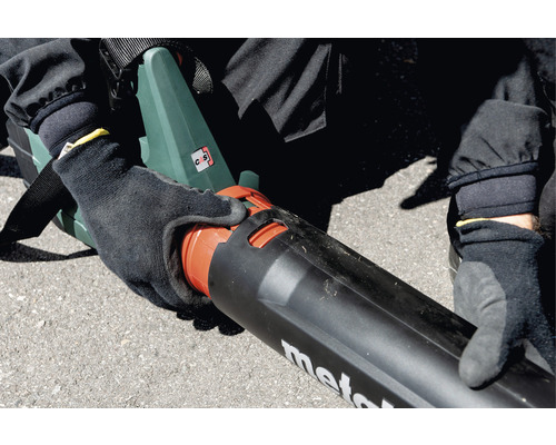 Person montiert Blasrohr an einem Laubbläser