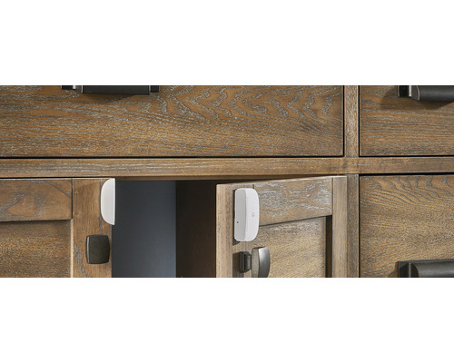 Intelligenter Tür- und Fenstersensor an einem Holzschrank