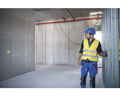 Handwerker verwendet einen Linienlaser zur Ausrichtung von Metallständerwerk im Rohbau